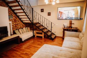 a living room with a staircase and a couch at Real home 1 in Sibiu