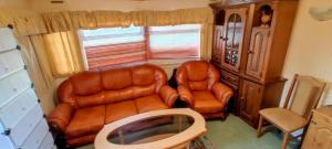 a living room with two leather chairs and a couch at #MazuryVillage in Wilkasy