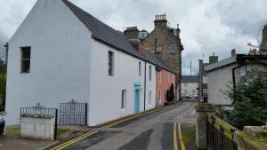a small street with white houses and a castle at Nairnia in Nairn