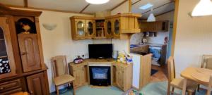 a kitchen with wooden cabinets and a desk with a television at #MazuryVillage in Wilkasy