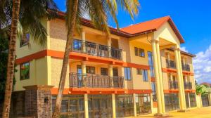 a building with palm trees in front of it at Royal Renaissance in Kumasi