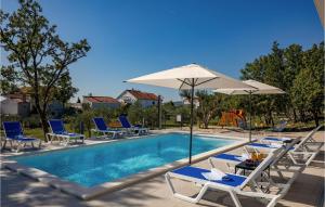 una piscina con sillas y sombrillas junto a ella en Villa Deep Green, en Maslenica