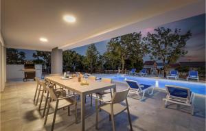 comedor con mesa, sillas y piscina en Villa Deep Green, en Maslenica 49 fotos más