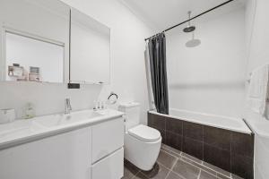 Un baño blanco con inodoro y lavabo. en Gorgeous Self Contained Home, en Sídney 14 fotos más