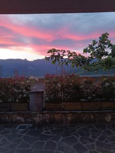 a sunset with a view of the water and trees at orminia house upper level in Monolíthion