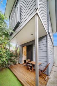 una terraza al aire libre con mesa y sillas en una casa en Gorgeous Self Contained Home, en Sídney