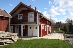 czerwona stodoła z werandą i tarasem w obiekcie Nolgårdens Turistboende w mieście Ugglum