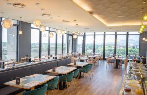 un ristorante con tavoli, sedie e ampie finestre di Dancewoods Hotel a Wujie