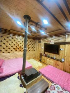 a room with two beds and a tv in a cabin at Janvi Homestay in Kalpa +28 photos