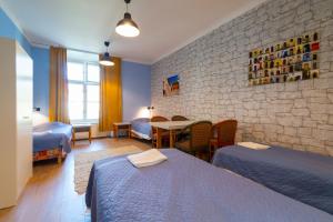 a room with two beds and a table with chairs at 16eur - Old Town Munkenhof in Tallinn +52 photos