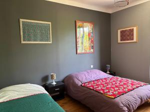 une chambre avec un lit avec une couverture rouge dessus dans l'établissement Havre de paix cosy avec jardin proche du centre-ville de Poitiers, à Poitiers