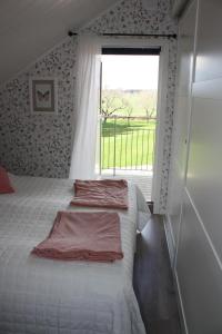 um quarto com uma cama e uma grande janela em Nolgårdens Turistboende em Ugglum