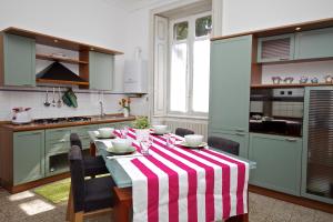 cocina con mesa y mantel de rayas rojas y blancas en Villa Farinelli, en Cadegliano Viconago