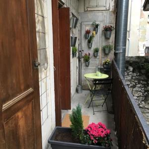 a small courtyard with a table and a door and flowers at Wine Home in Chambéry