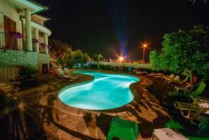 una piscina en un patio por la noche en Guesthouse Villa Lena en Premantura
