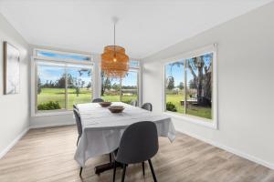 ein Esszimmer mit Tisch und Stühlen und Fenstern in der Unterkunft Madigan Cottages - Australiana in Lovedale + 16 Fotos