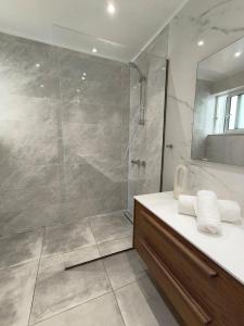 a bathroom with a shower and a sink and a mirror at Downtown Luxury Apartment in Rhodes Town