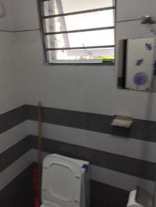 a bathroom with a toilet with striped walls and a window at Thrikarthika appartments in Guruvāyūr +6 photos