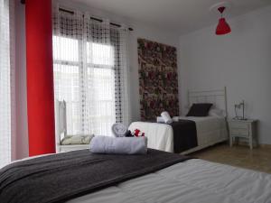 コニル・デ・ラ・フロンテーラにあるHostel Conilの赤い壁のベッドルーム1室(ベッド2台付)