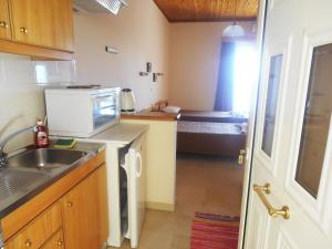a small kitchen with a sink and a microwave at Panorama in Perama