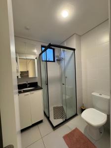 a bathroom with a shower and a toilet and a sink at Apto completo, Piscina, Cinema, Home Clube e Jardim in Piçarras