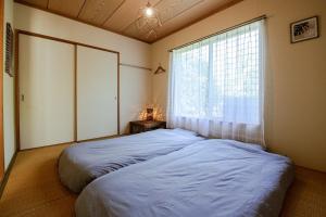 a bedroom with a large bed and a window at Marine Villa Ilio in Sumoto