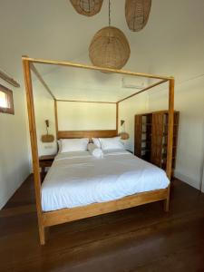 1 dormitorio con cama con dosel y sábanas blancas en Goofys Hotel - Yoyos Sekongkang Sumbawa, en Sekongkang Bawa 25 fotos más
