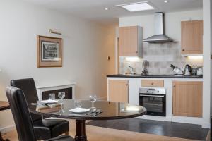 - une cuisine et une salle à manger avec une table et des chaises dans l'établissement The Angel Posting House & Livery, à Guildford