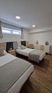 Un dormitorio con dos camas y una ventana. en Apartamentos Playa de Camariñas, en Camariñas