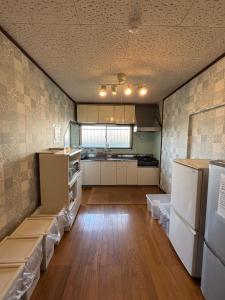 a large kitchen with white appliances and wooden floors at condominium [Signal Resort] in Kujukuri