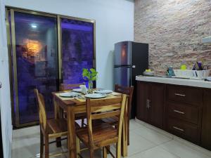 a kitchen with a wooden table and a refrigerator at Chan Kiin Departamentos in Valladolid