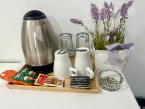 a tray with a coffee maker and a vase of flowers at Apartments Ana & Ita in Novalja