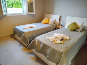 two beds with towels on them in a room at Villa Lemonia in Kalami