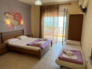 a bedroom with two beds and a window with a view at Studios-Heaven in Chrysi Ammoudia