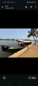 un bateau garé sur le bord d'une rivière dans l'établissement PM shikkara boat, à Alappuzha