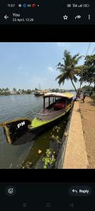 un bateau dans l'eau à côté d'un quai dans l'établissement PM shikkara boat, à Alappuzha
