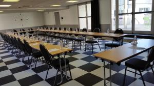 a row of tables and chairs in a room with checkered floor at Hotel Kyriad Tours St Pierre des Corps Gare in Saint-Pierre-des-Corps