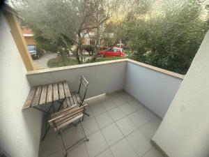a balcony with a bench and a view of a street at Apartments Ana & Ita in Novalja