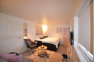 a hotel room with a bed and a chair and a table at H sweet H apartment free parking in Tromsø