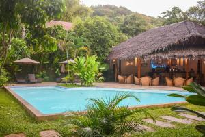 a swimming pool in front of a villa at El Nido Coco Resort in El Nido