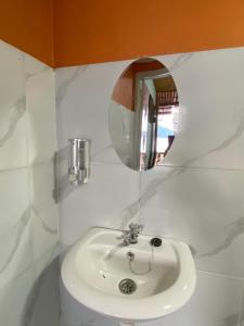a bathroom with a white sink and a mirror at Three Ken Homestay & Cafe in Manado +142 photos