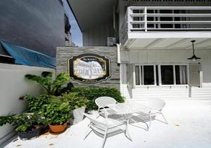 a patio with a table and chairs in front of a building at RQ THEVA Heritique Baan Praya Dinsor Road in Bangkok +28 photos