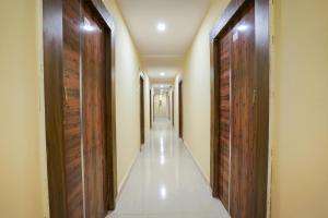 a hallway with wooden doors and a long corridor at Hotel O R Square Stay Near LB Nagar Metro in Hyderabad