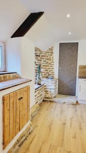 a kitchen with wooden floors and a stone wall at KerLudi Le Ptit St Roch, gîte de charme 5km de la mer in Ploudalmézeau +9 photos