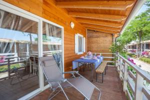 a patio with a table and chairs on a deck at La Mimosa Camping in Fano
