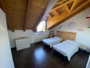 due letti in una stanza con soffitti in legno di Salcasavacanze a Castelletto sopra Ticino Altre 4 foto