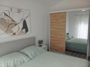sypialnia z 2 łóżkami i dużym lustrem w obiekcie Apartment Flowers w Bibinje