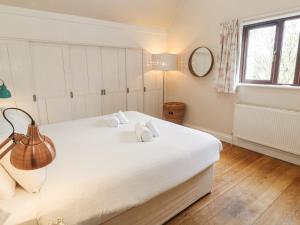a bedroom with a large white bed with towels on it at 6 The Links in Penzance