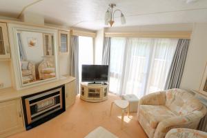 a living room with a couch and a television at Hof Nieuwerkerk Chalet 2 in Arnemuiden