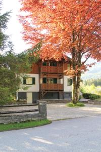 a large house with a porch and a tree at Villa Silvanus in Ebensee